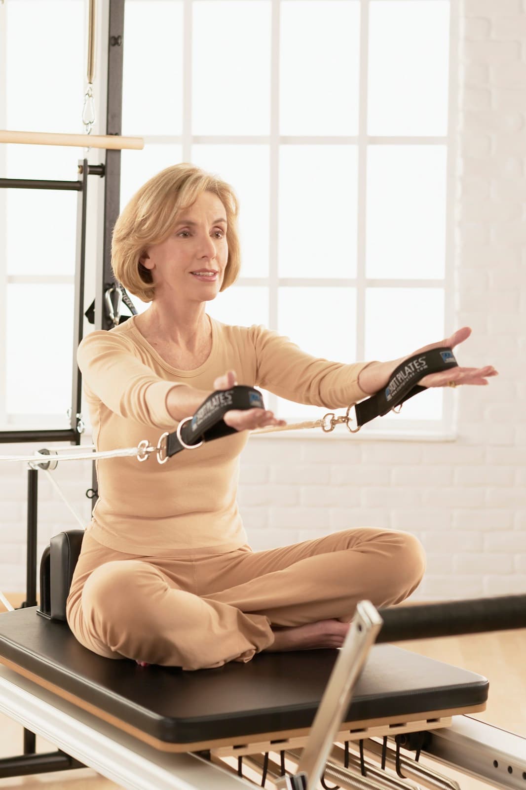 Seated work on the reformer with hand straps during a clinical session